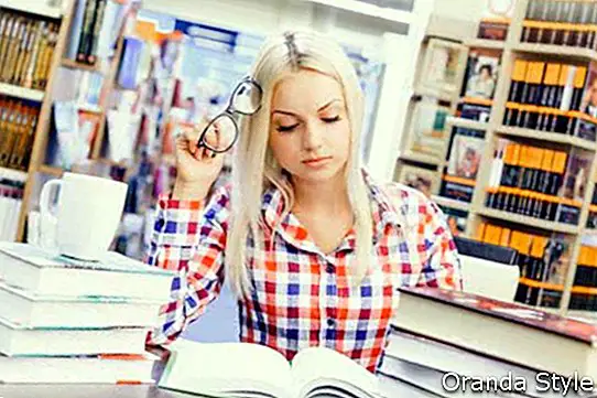 אישה צעירה ויפה לומדת בספריה