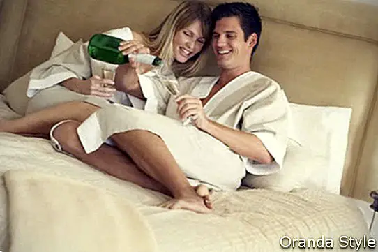 junges Paar Champagner im Schlafzimmer genießen