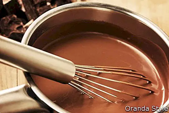 Ahşap masa üzerinde bir tencerede sıcak çikolata hazırlama