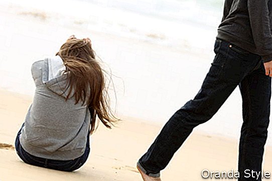 trieste vrouw zittend op een strand