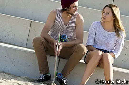 jauna pora sėdi ant didelių betoninių laiptelių