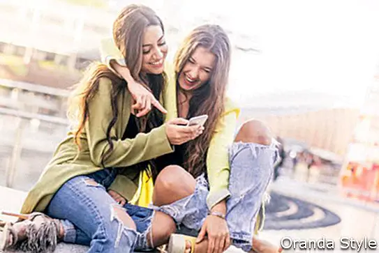 Еуфорични приятели, гледащи видеоклипове на смартфон и насочени към екрана изненадани