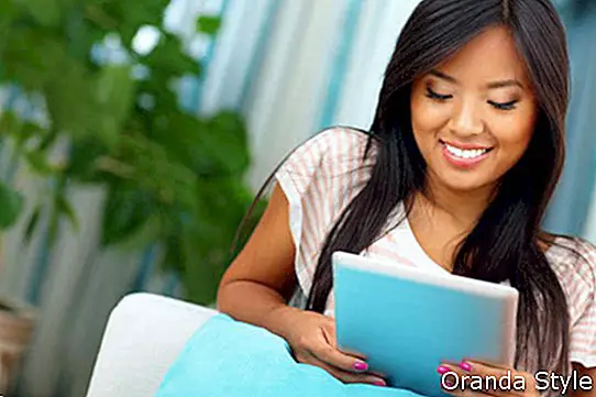 Õnnelik-noor-aasia-naine-sirvib Internetti-tema-tahvelarvutiga