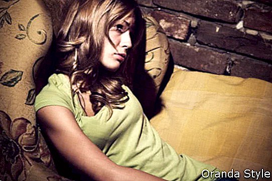 noor naine istub tugitoolis, olles depressioonis