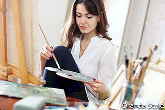 Pikakarvaline ilus kunstnik maalib töökojas lõuendil