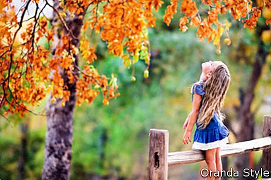 Gadis kecil yang cantik bersantai di pemandangan musim gugur yang indah