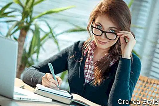 Mladá žena v brýlích studuje