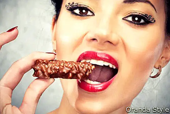 Mujer bonita con maquillaje comiendo chocolate