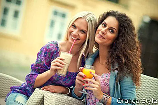 dve ženski prijateljici v kavarni, ki se zabavata in pogovarjata