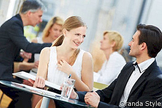 Người đàn ông và người phụ nữ kinh doanh tán tỉnh ngoài trời trong một quán cà phê
