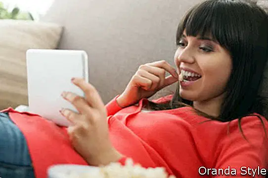 người phụ nữ xem video trực tuyến và ăn bỏng ngô