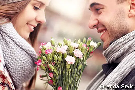 Una foto de un hombre regalando flores a su amante en un día de invierno