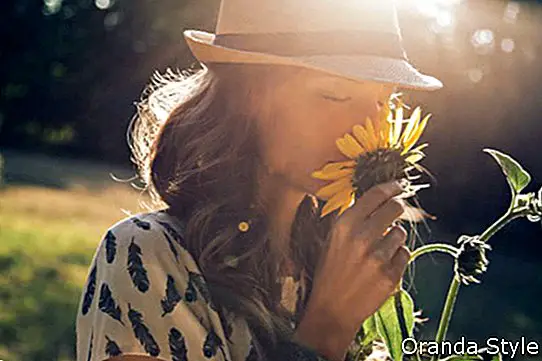 Момиче мирише на слънчоглед в природата