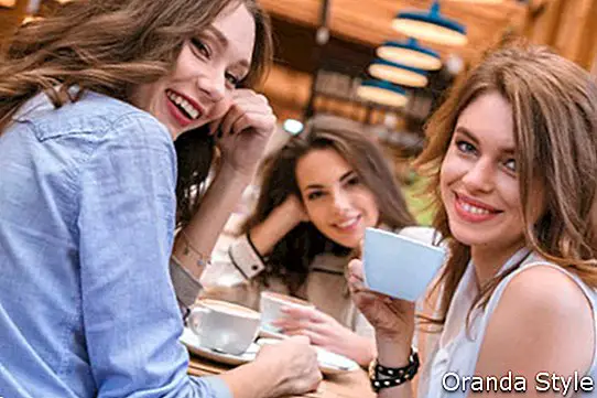 Retrato de tres novias tomando café en la cafetería juntos