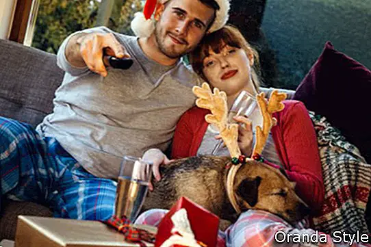 Cặp vợ chồng trẻ ở nhà với con chó cưng của họ vào thời điểm Giáng sinh