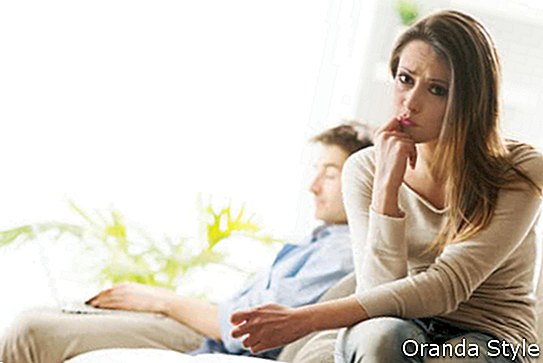 Gros plan femme triste avec son petit ami sur fond assis sur le canapé