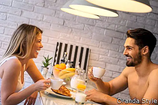 คู่รักเพลิดเพลินกับกาแฟยามเช้าและอาหารเช้าด้วยกัน