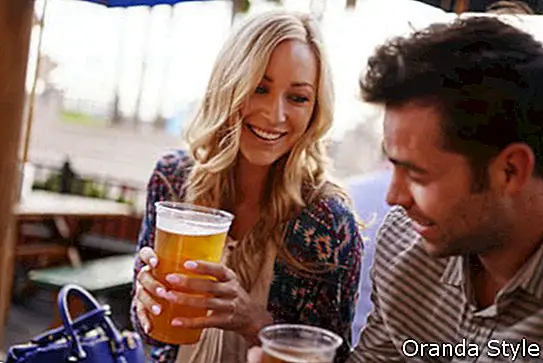 romantisks pāris dzer alu āra restorānā