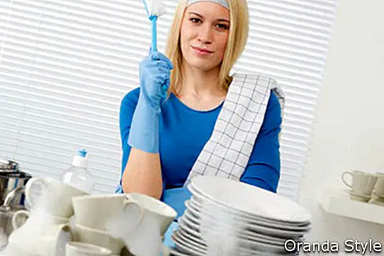 mulher feliz lavando pratos