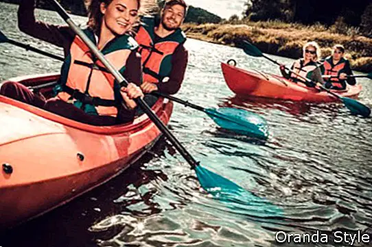 Felices mejores amigos divirtiéndose en un kayaks