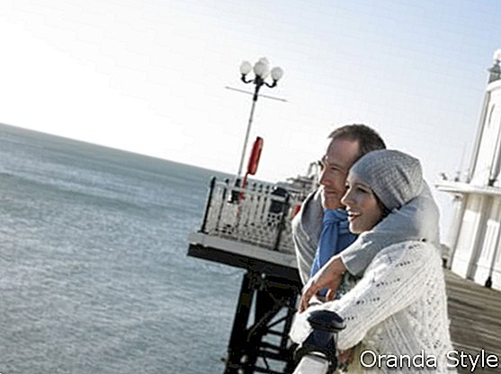 Paare, die auf dem Pier heraus betrachtet Meer stehen