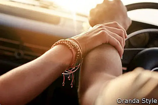 Cierre plano de pareja amorosa que viaja en coche y cogidos de la mano