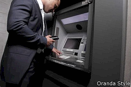 Geschäftsmann, der Bargeld von ATM-Maschine nimmt