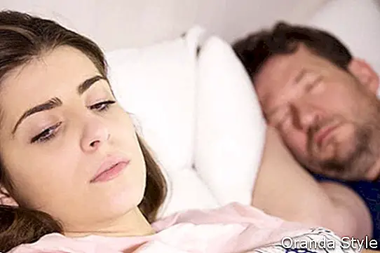 liūdna moteris guli lovoje