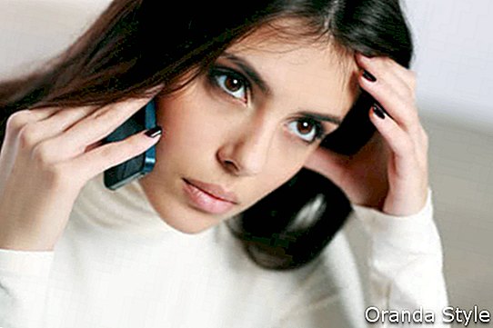 Молода жінка задумливою говорити по телефону