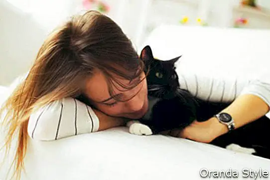 Vakker jente sover med en katt
