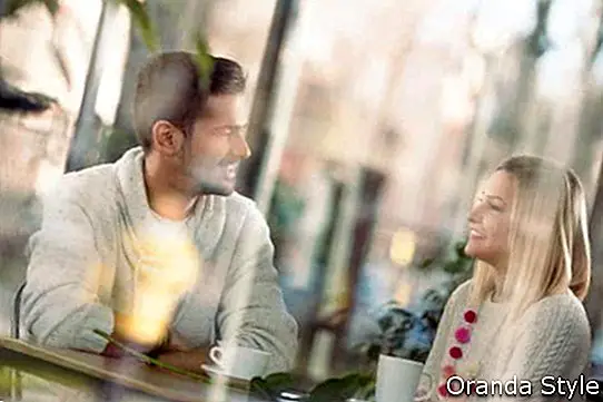 Alegre joven pareja en una cita romántica en un café