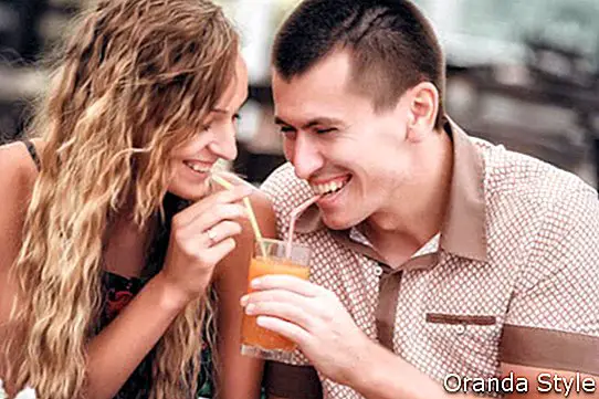 junges Paar mit Getränken im Café im Freien