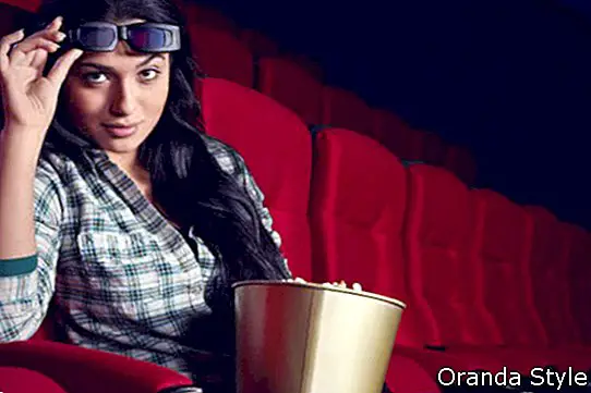 Mädchen mit 3D-Brille und Popcorn im Kino