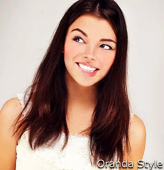 Grožio jaunos brunetės moters portretas su gražia šypsena