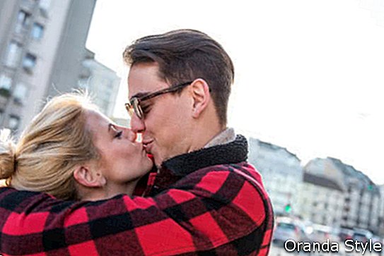 Mladi eleganten simpatični par, ki se poljublja in zabava na prostem na zmenku