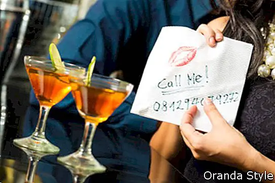 žena zvádza muža v reštaurácii a dáva mu číslo na obrúsku