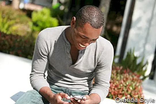 noor must tüüp loeb oma telefonis tekstsõnumit