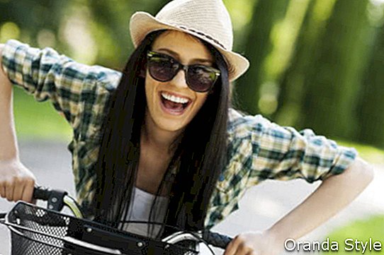 Laimīga, jauna sieviete, ar velosipēdu