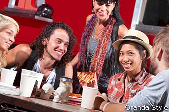 Miela Azijos moteris su hipsterių draugais, valgantys picą lauke