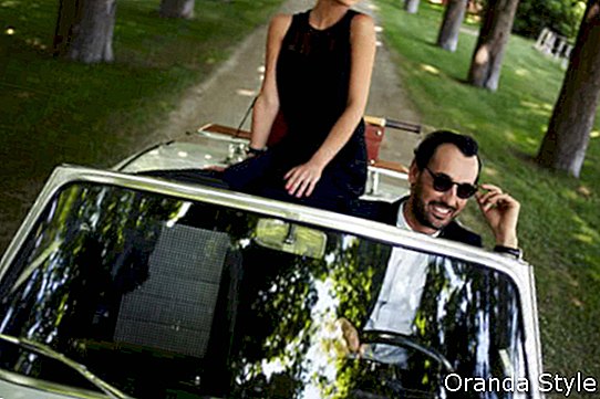 Srečen par poleti uživa v vožnji na svojem luksuznem kabrioletu