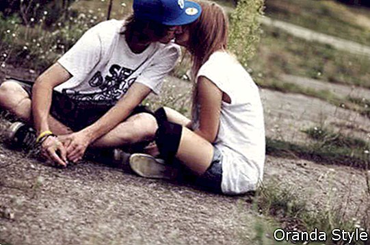 pareja sentada en el suelo y besándose
