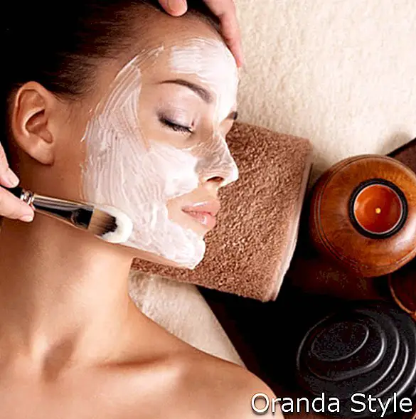 Lázeňská terapie pro mladou ženu přijímající obličejovou masku v salonu krásy