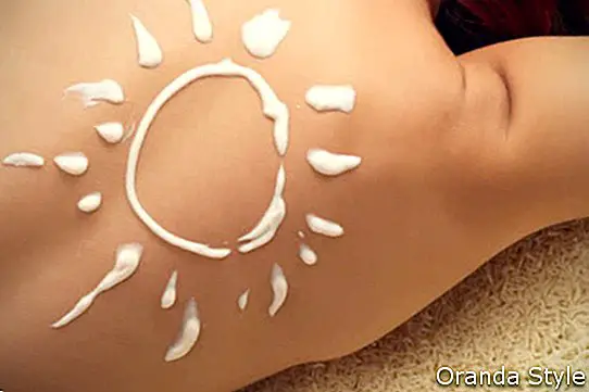 crema de protección solar en la espalda de la mujer