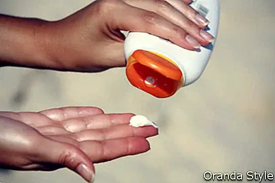 close up tangan wanita yang menerima lotion krim tabir surya