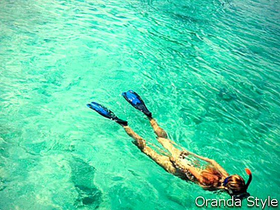 mladá žena sa šnorchluje v tropických lagúnach