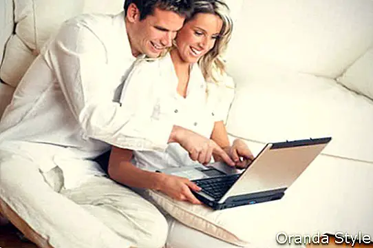 lächelnde paar mit laptop
