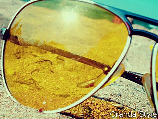 Saulesbrilles vasarā uz smiltīm pie jūras