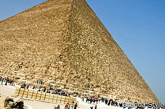 観光客と先住民はエジプトのピラミッドのふもとにいます