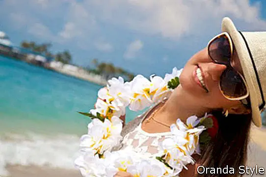 Hawaii naine, kellel on valge plumeria lille lei-vanik